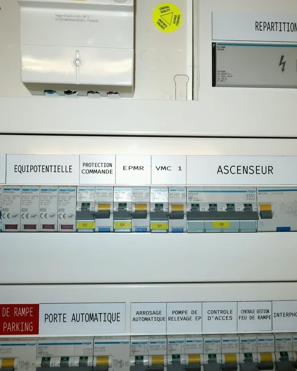 Tableau de distribution tertiaire, départs repérés&nbsp;: ascenseur, VMC, porte automatique.